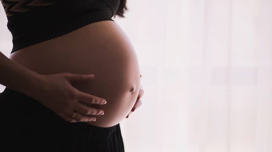 Pregnant woman holding her belly.